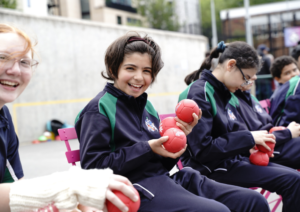 Children holding Cricket balls and smiling