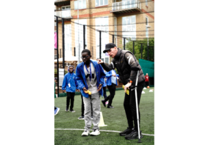 Coach instructing young person how to play Cricket